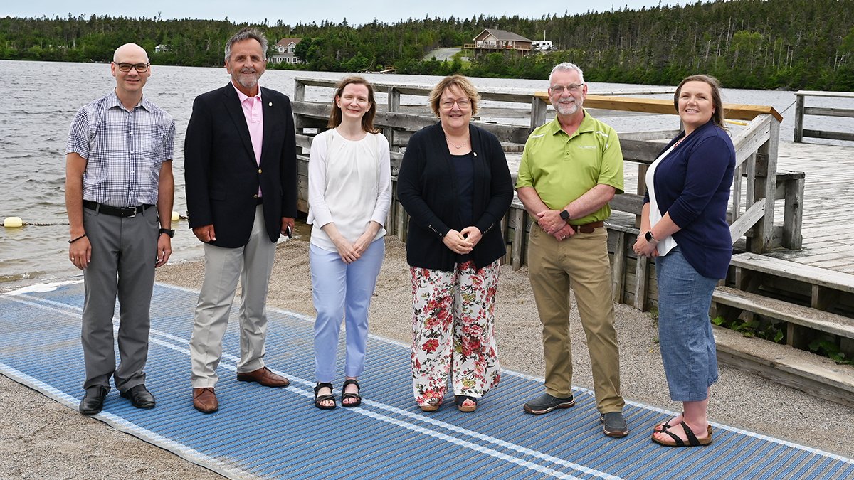 From left to right, Joby Fleming, City of St. John’s Inclusion Advisory Committee Co-Chair; George Tilley, Past-President of the Rotary Club of St. John’s; Krista Gladney, Manager of Healthy City and Inclusion with the City of St. John’s; Nancy Hollett, President of the Rotary Club of St. John’s; Danny Breen, Mayor of the City of St. John’s, Trisha Rose, Accessibility Facilitator with the City of St. John’s; gather at Rotary Sunshine Park on the new beach mat. 