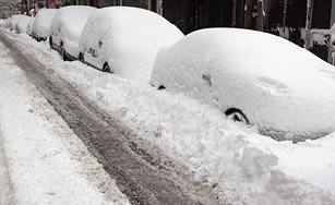 cars parked on a street covered in snow. 