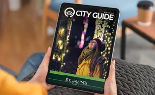 a person holding a copy of the 2025 Winter City Guide. 