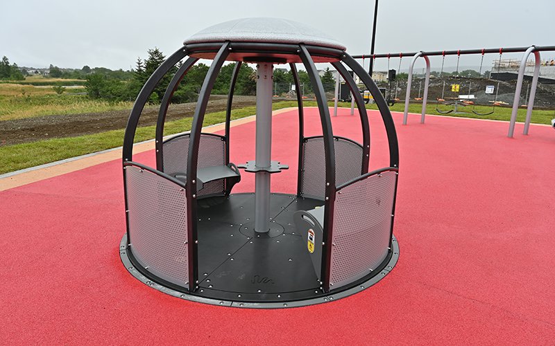 Photo of an accessible piece of merry-go-round playground equipment